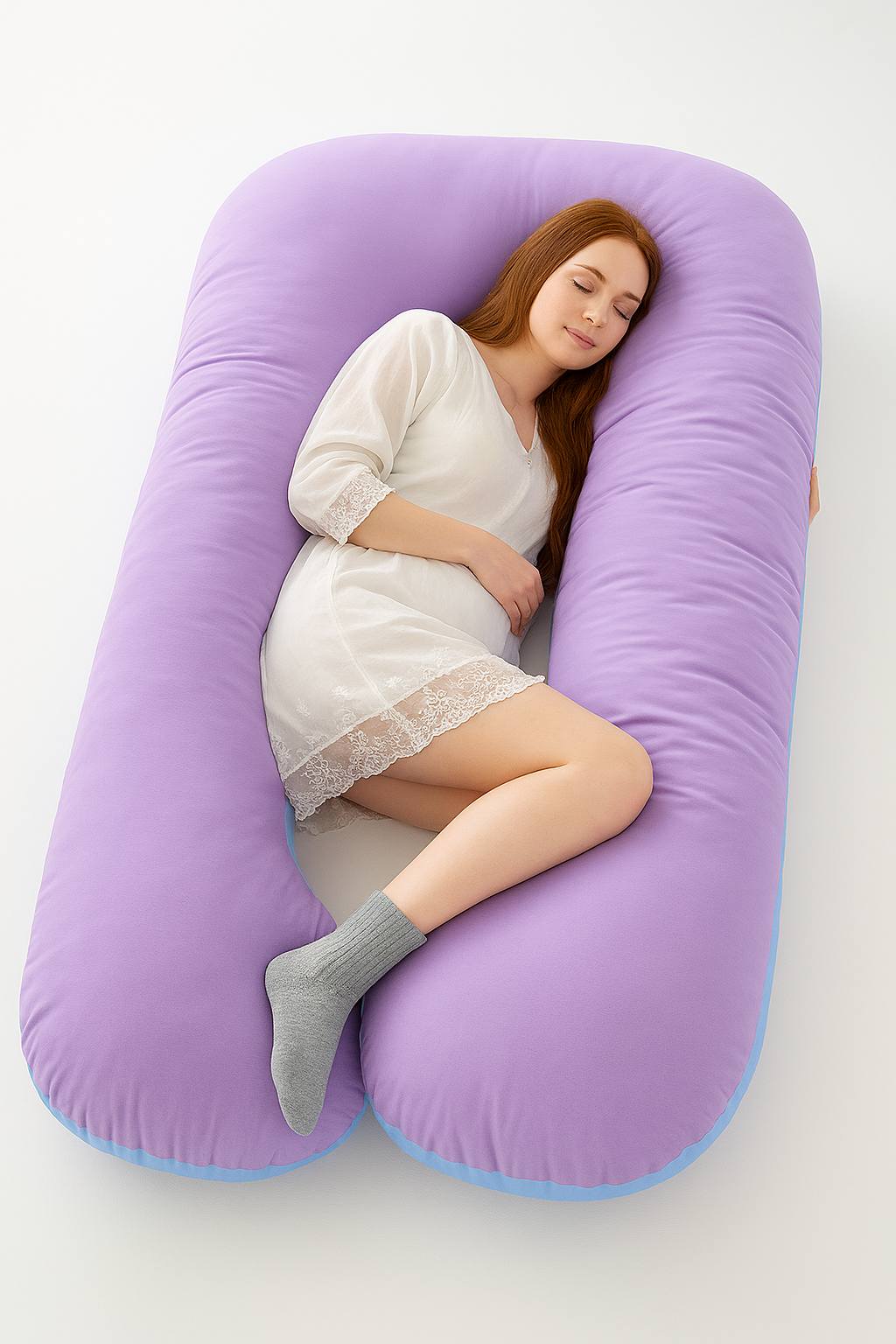 Woman lying on a large purple U-shaped pillow on a white background